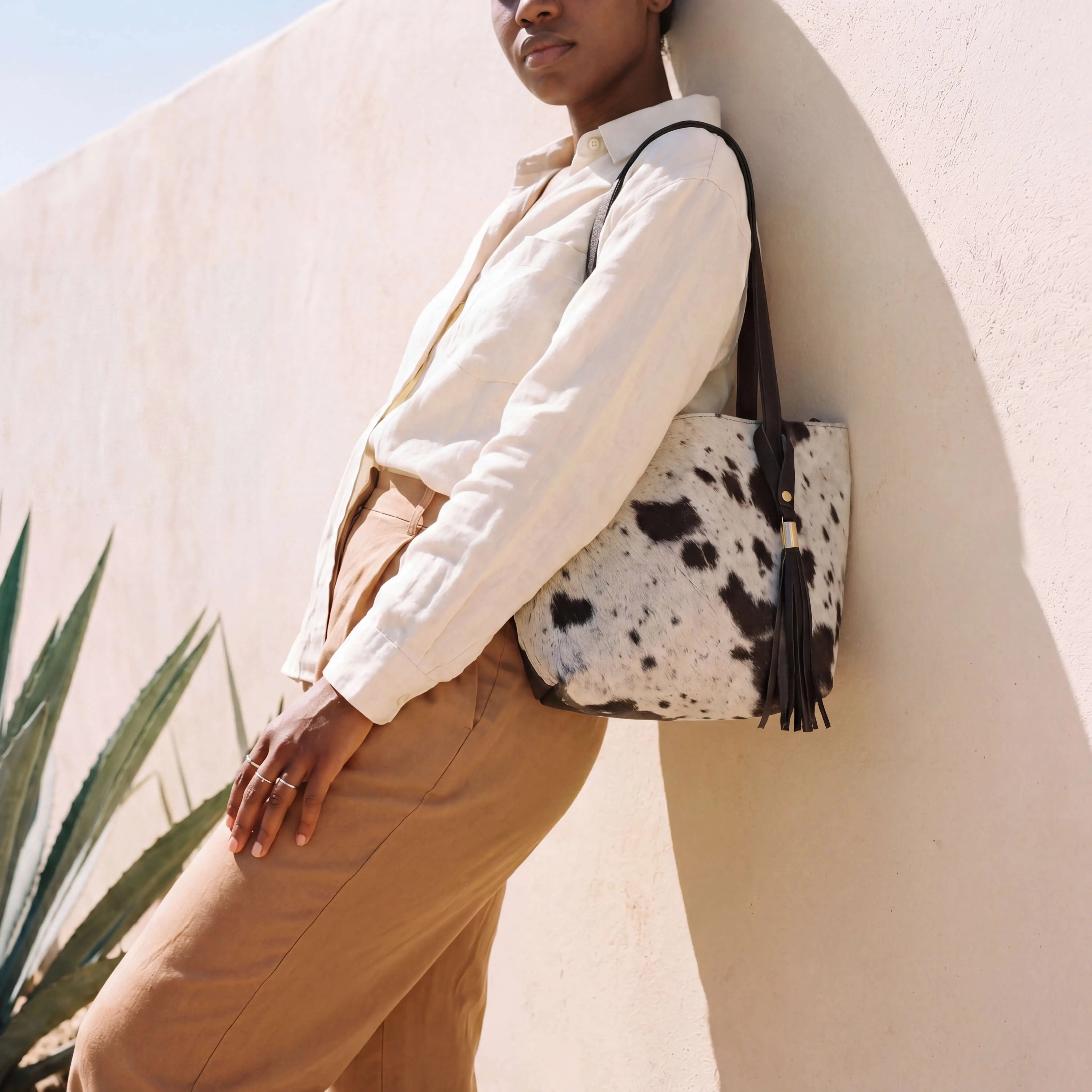 Sangre de Mar Atlantica hair-on-hide tote in brown and white with dark leather straps and tassel