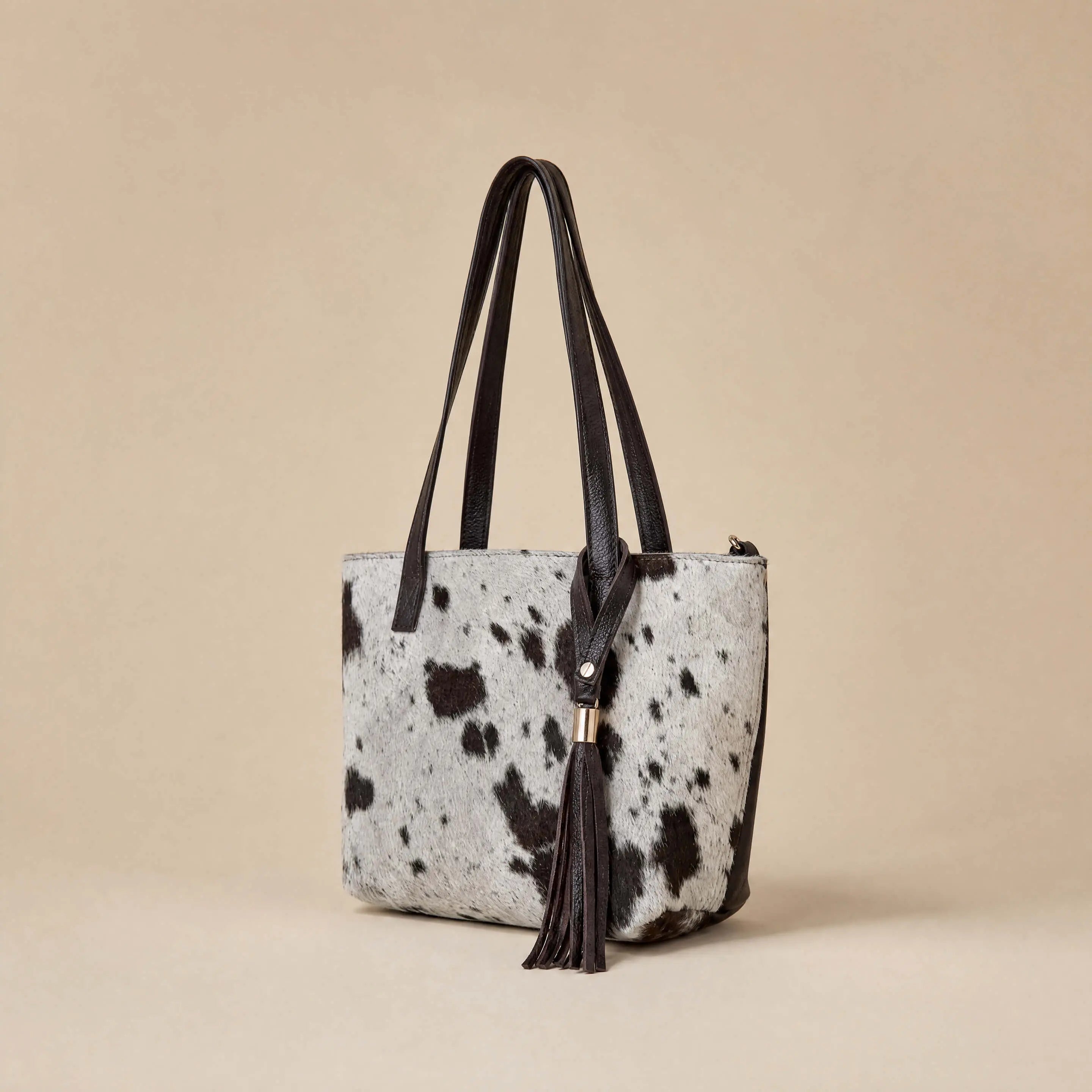 Handcrafted leather tassel and gold hardware detail on Sangre de Mar hair-on-hide tote
