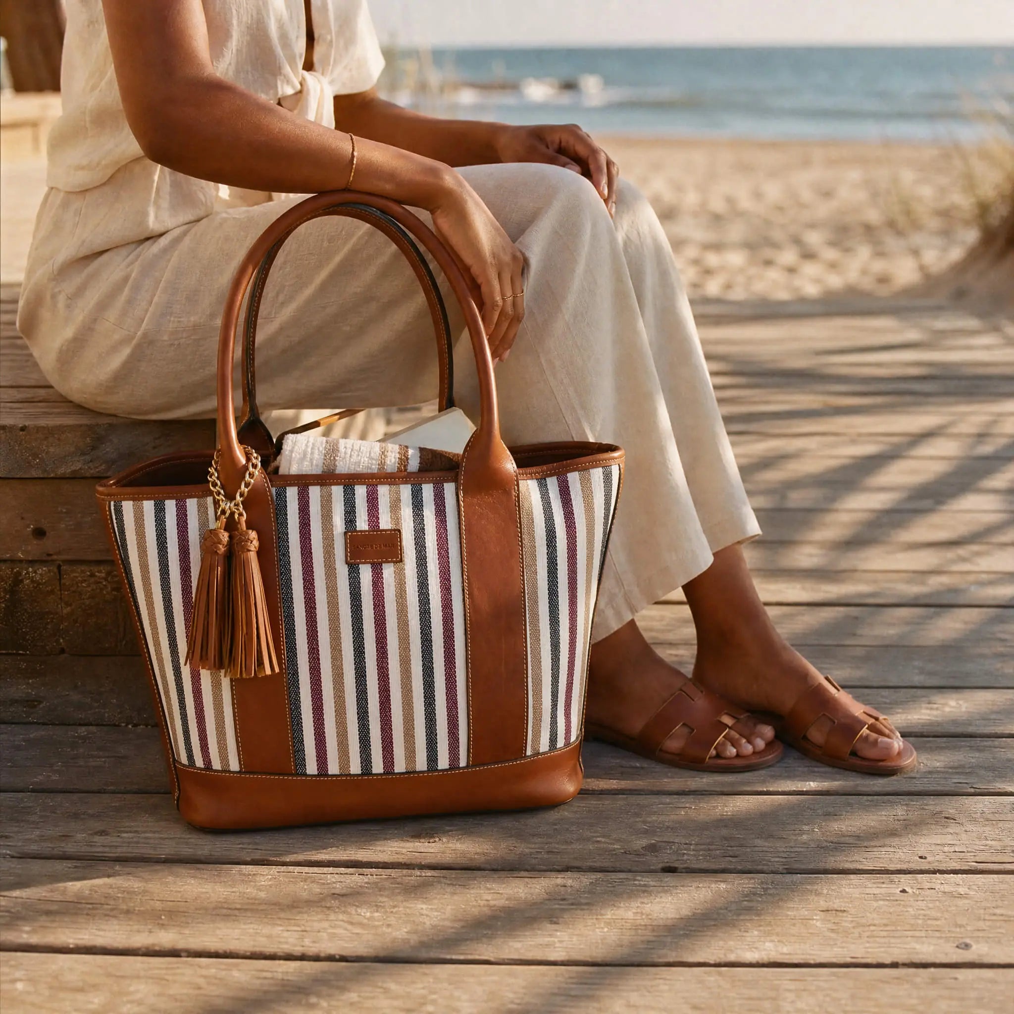 Riviera Carryall Tote — multicolour striped canvas & tan leather — front view with tassel | Sangre de Mar handcrafted leather