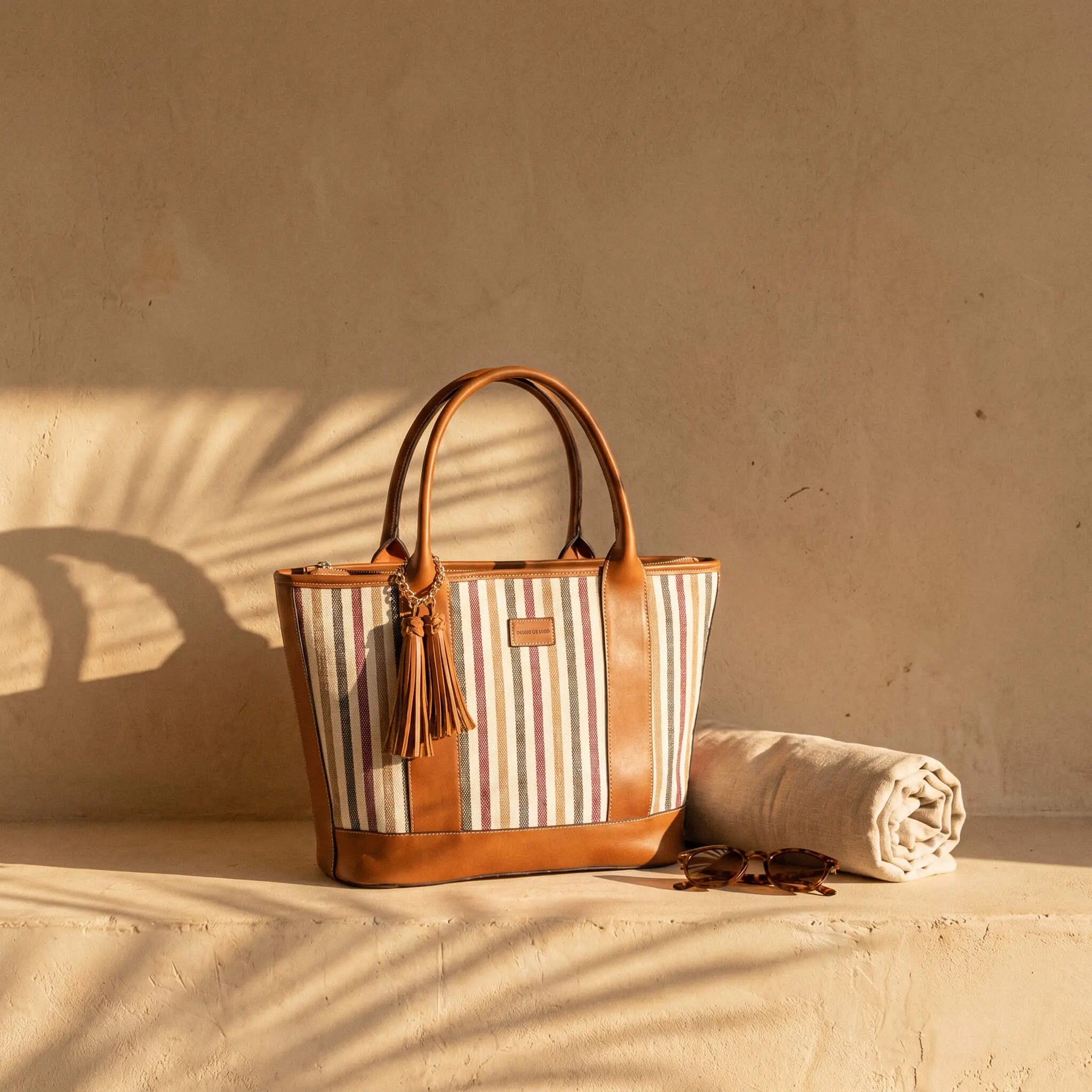 Riviera Carryall Tote — multicolour striped canvas & tan leather — front view with tassel | Sangre de Mar handcrafted leather