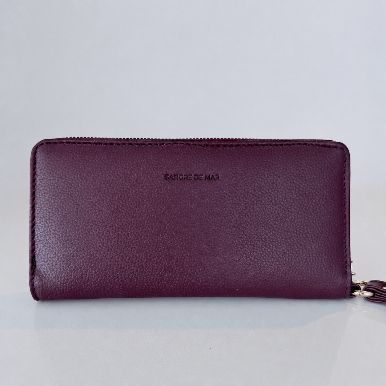 Merlot wallet with 'Sangre de Mar' branding on a light gray background