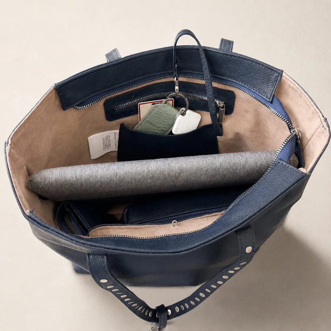 Aereal view of the Marea tote bag in navy blue with studs and amulets, styled sangre de mar 